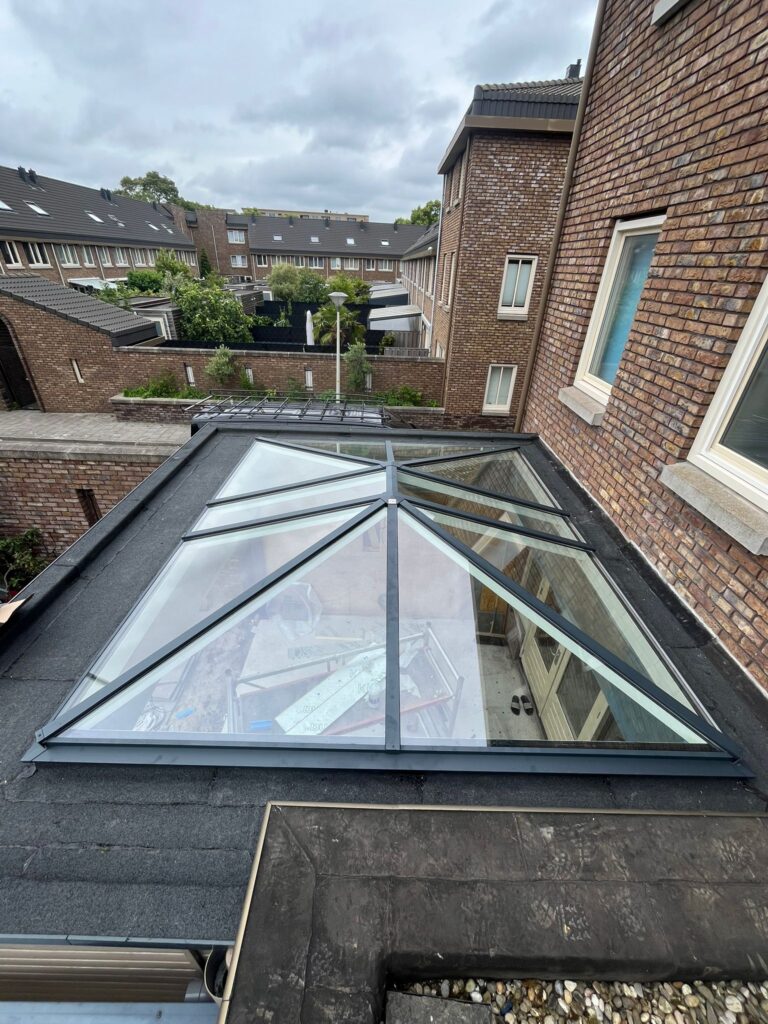 Plaatsing van een groot glazen daklicht met aluminium profielen in een bestaande uitbouw in Wageningen