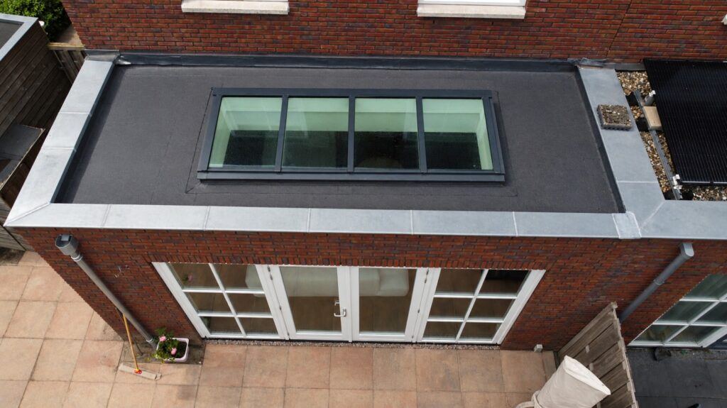 Plat dak van de uitbouw in Oostzaan met langwerpige lichtstraat