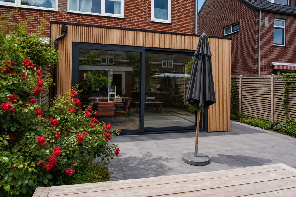 Uitbouw aan woning in Austerlitz met verticale houten gevelbekleding en grote glazen pui