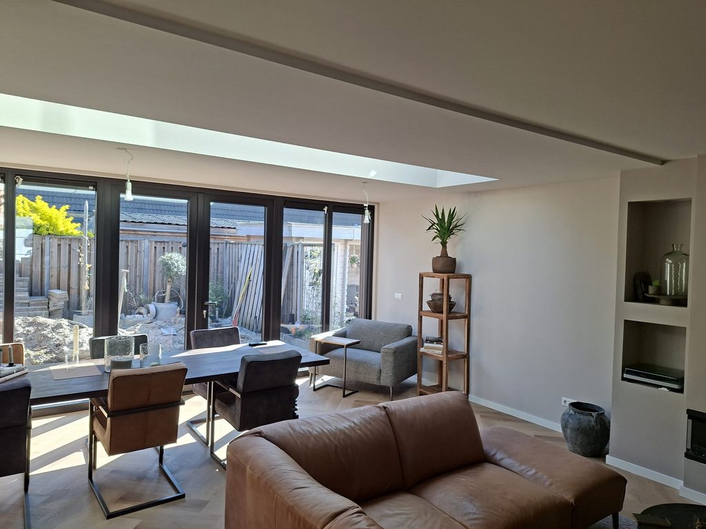 Afgewerkte uitbouw van de woonkamer in Hellevoetsluis met lichtstraat en grote glazen achtergevel