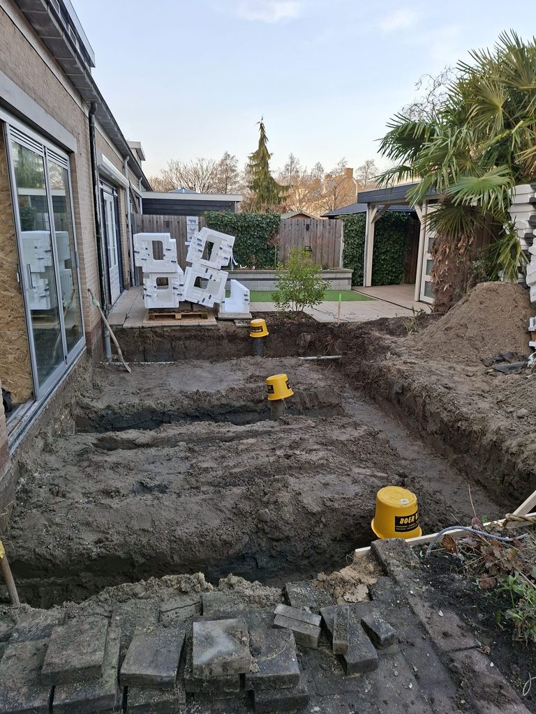 Grondwerk voor de uitbouw in Hellevoetsluis met uitgegraven fundering en heipalen